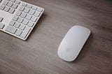 A mouse and keyboard on a wooden table