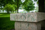 The word “dignity” inscribed on a stone.