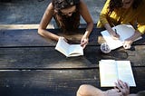 Three people reading and writing.