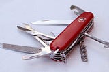 A red Swiss Army Knife with various tools opened