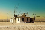 An abandoned house in a barren landscape.