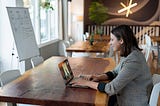 Girl sitting at a desk with an Ipad in front of her.