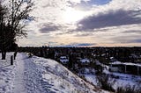 Snowy hilltop views of faraway mountains