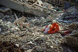 Stuffed animals lying in the rubbled of a bombed-out building