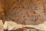 A prehistoric cave painting of several four-legged animals in a variety of colours and styles