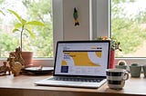 A laptop sitting by a window with plants and a coffee mug next to it.