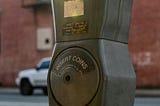 A close-up of a vintage metal parking meter with the red flag showing, indicating the time is about to expire or has already run out. A metaphor for limited time and the cost of friction.