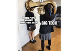 Meme showing a girl holding a tuba over another girl’s face. The one holding the tuba is labeled “BIG TECH”, the tuba is labeled “AI”, and the poor girl getting honked in the face is labeled “NORMAL PEOPLE WHO JUST WANT TO USE AN APP”