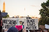 Photo of Black Lives Matter protesters in Washington, D.C. — 2 signs say “Black Lives Matter” and “White Silence is Violence”