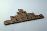 A series of scrabble blocks that spell ‘I am still learning’