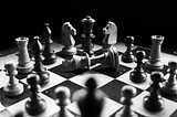 Black and white photo with a chessboard and chess pieces.