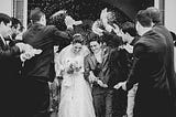 Bride and groom guests throwing confetti. Black and white image.