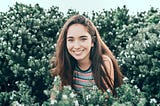 Happy Smiling Girl next to flowers