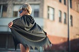 A little boy in a super hero mask and cape