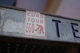 An image of a street sign telling people to ‘curb their ego’.
