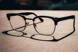 A pair of vintage horn-rimmed glasses photographed aesthetically