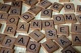 Scrabble pieces on a table spell random in middle