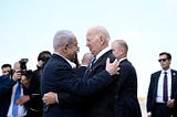 Israeli Prime Minister Benjamin Netanyahu (L) greets US President Joe Biden upon his arrival at Tel Aviv’s Ben Gurion airport on October 18, 2023
