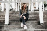 Girl sitting on stairs in front of a house