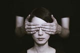 Man covering eyes of woman