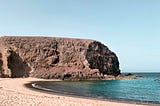 The writer pictures a beach in NW Spain and denotes it as his backyard.