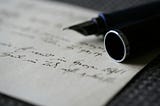 A fountain pen lying on handwritten paper