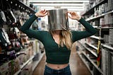 A woman with a pot on her head, trying to hide from a situation
