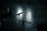A dark stage with a microphone.