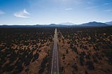 Aerial photo of a long stretch of highway traveling off into the mountains.