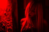 Spooky-looking picture of a woman — the whole image is washed a moody red