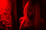 Spooky-looking picture of a woman — the whole image is washed a moody red