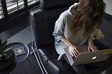 A woman sitting on chair and working on laptop