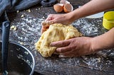 Picture of a person’s hands kneading a ball of dough.