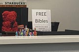 A sign that reads “Free Bibles Read the story about Christmas page 2:1–20 page 102–103”