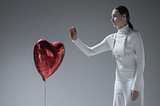 A lady dressed in all white about to pop a red heart shaped balloon symbolizes a woman strong enough to stick to her non negotiables in dating and not waste her time.