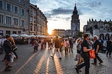 Photo of people walking around main market square in Cracow, Poland.