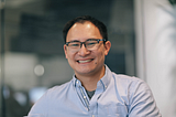 A portrait of Mike Wu, Deputy General Counsel at Carta. He’s smiling.