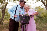 A man kissing his elderly wife on the head as they interrupted their ride
