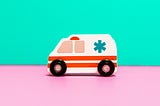 A cartoon illustration of an ambulance driving to the left on pink pavement. The sky is green.