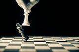A chess piece knocking another chess piece over