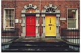 Row housing with two doors to choose, one yellow on the right and a red one on the left.