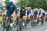 A group of professional cyclists in spanks and helmets and sunglasses.