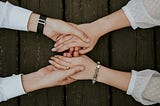 Two people holding hands over a table