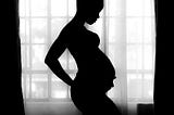 Pregnant woman in shadow