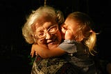 Grandchild hugging her grandmother with love
