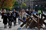 People walking past anti-tank hedgehogs