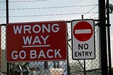 “Wrong Way — Go Back” and “No Entry” signs