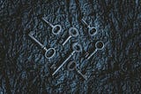 A black background with 7 metal keys lying on it.