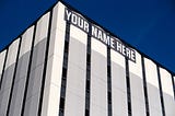 Building with banner that reads “YOUR NAME HERE”