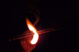 A matchstick burning out in the dark